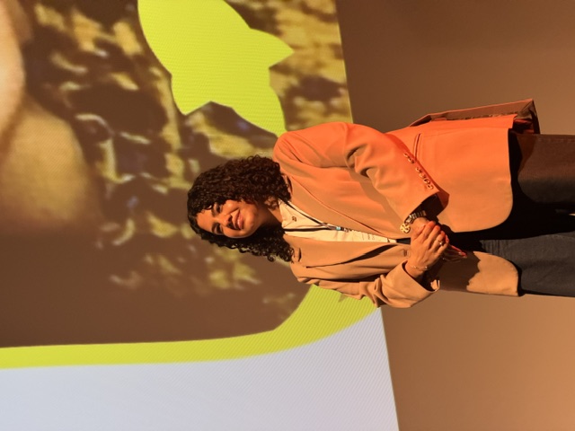 A speaker on stage at a FemTechConf summit
